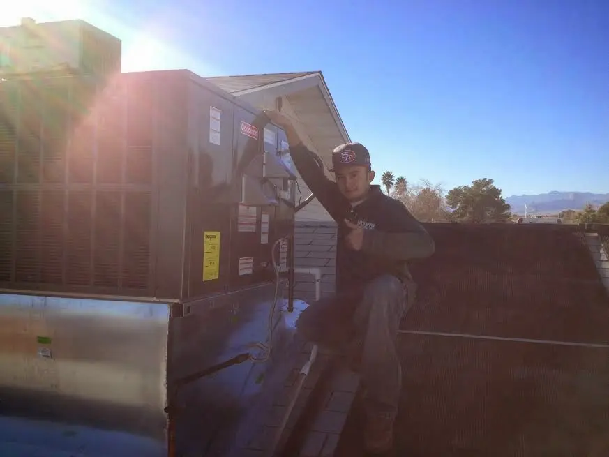 HVAC technician performing AC Tune-Up on a rooftop unit in Fuller Heights